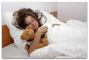 Девушка спит с плюшевым медведем