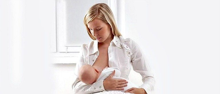 Девушка кормит грудью малыша
