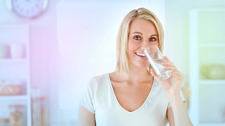 Женщина пьет чистую воду